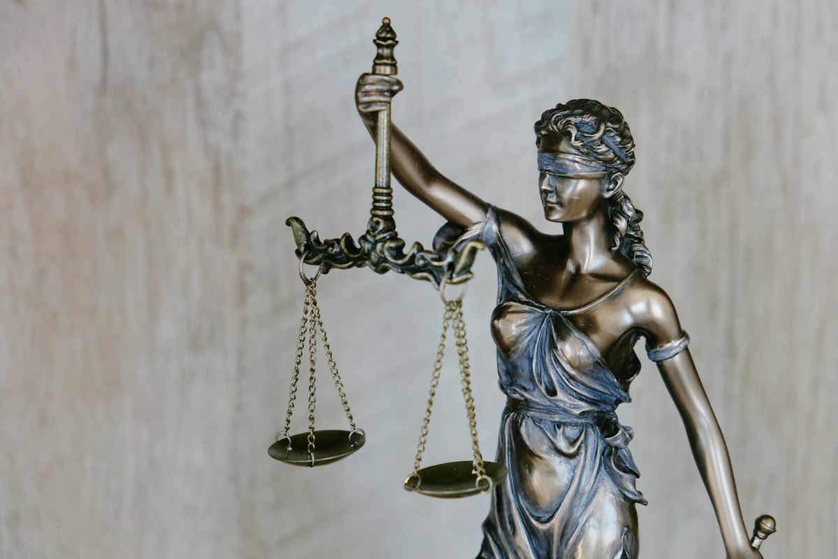 Mazo y libros de derecho que representan la actuación de un perito judicial tributario